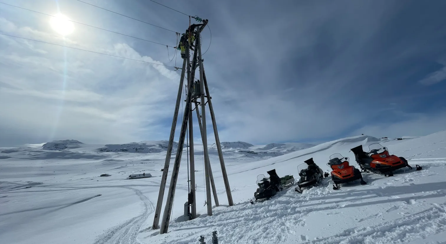 4 Parkerte snøskutere i hvit snødekt vidde. Foto.